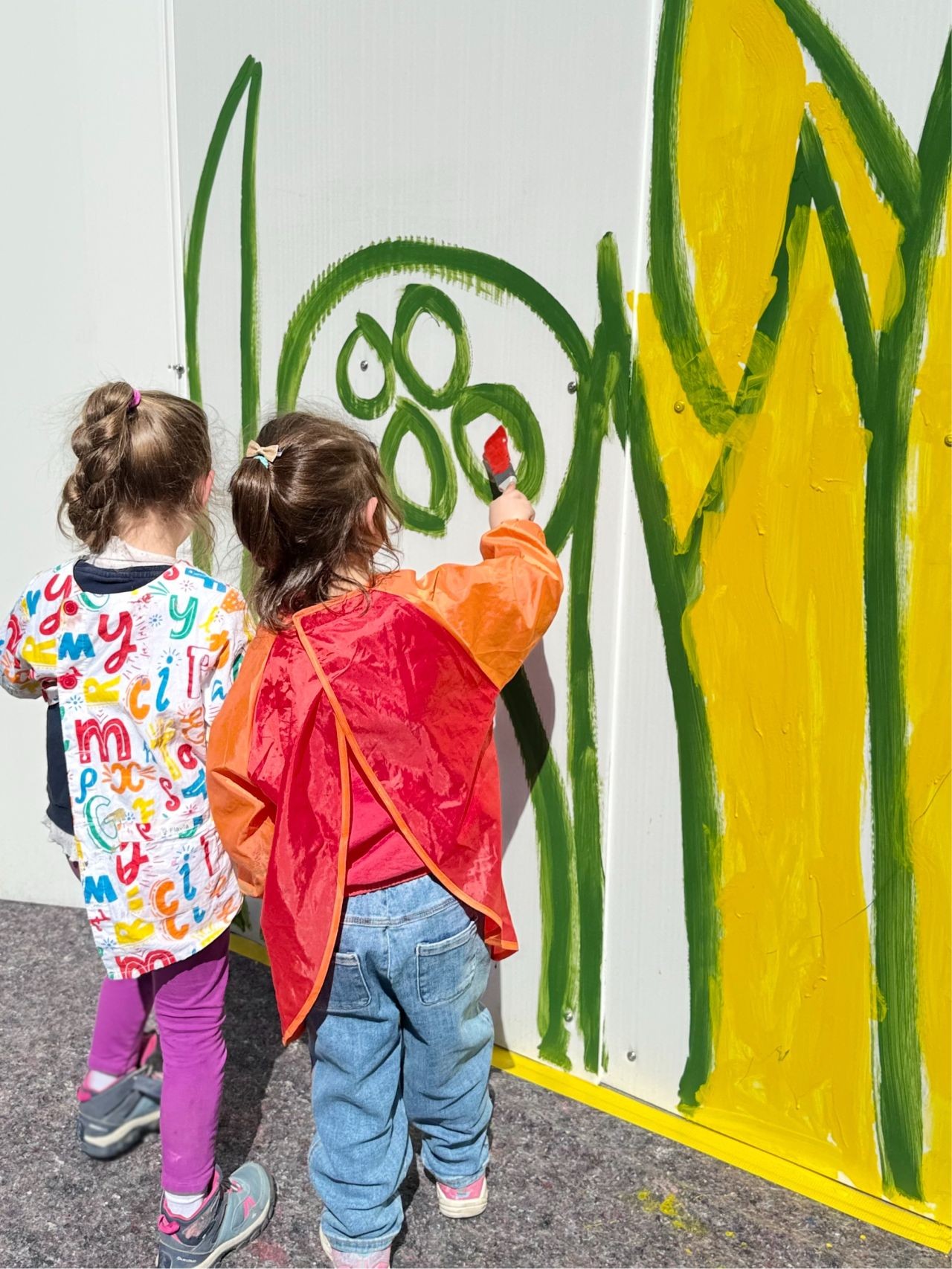Kindergartenschüler bringen Farbe auf die Baustelle